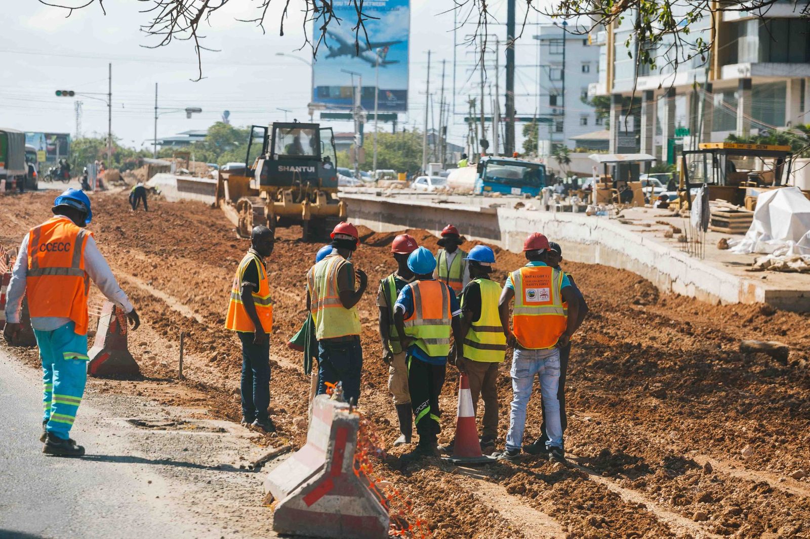 A crew in safety vests on a dirt jobsite
