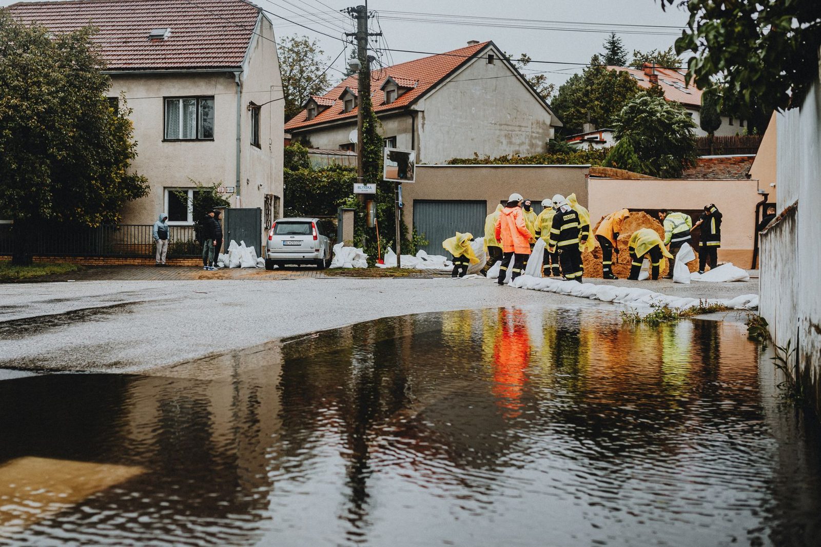 A crew placing sandbags on a flooded street