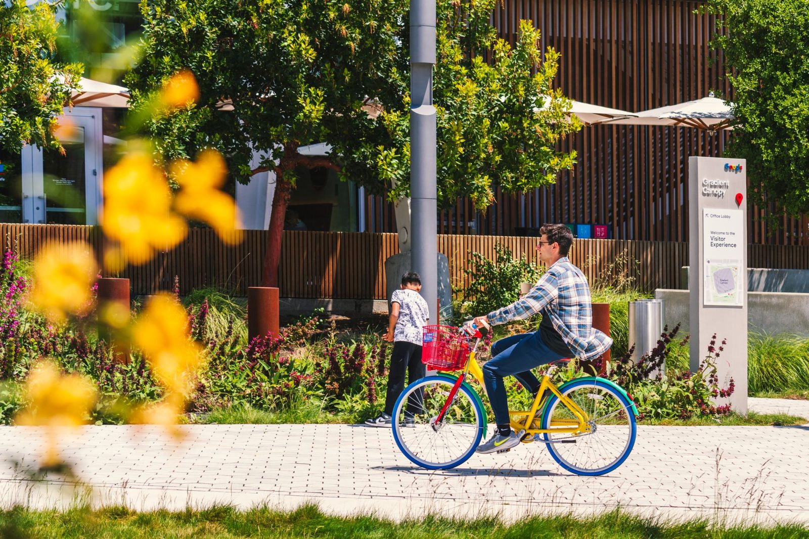 A cyclist on a flower lined campus path