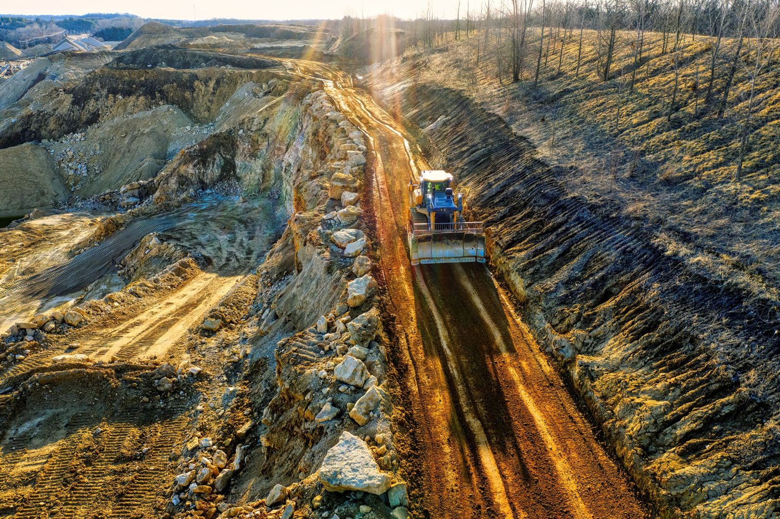 A dozer grading a long cut across a site