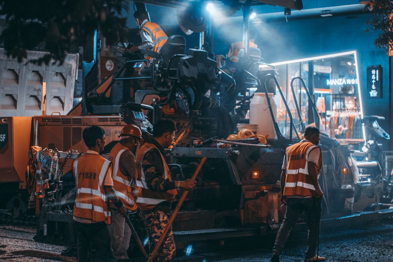 A night crew in safety vests working with heavy equipment