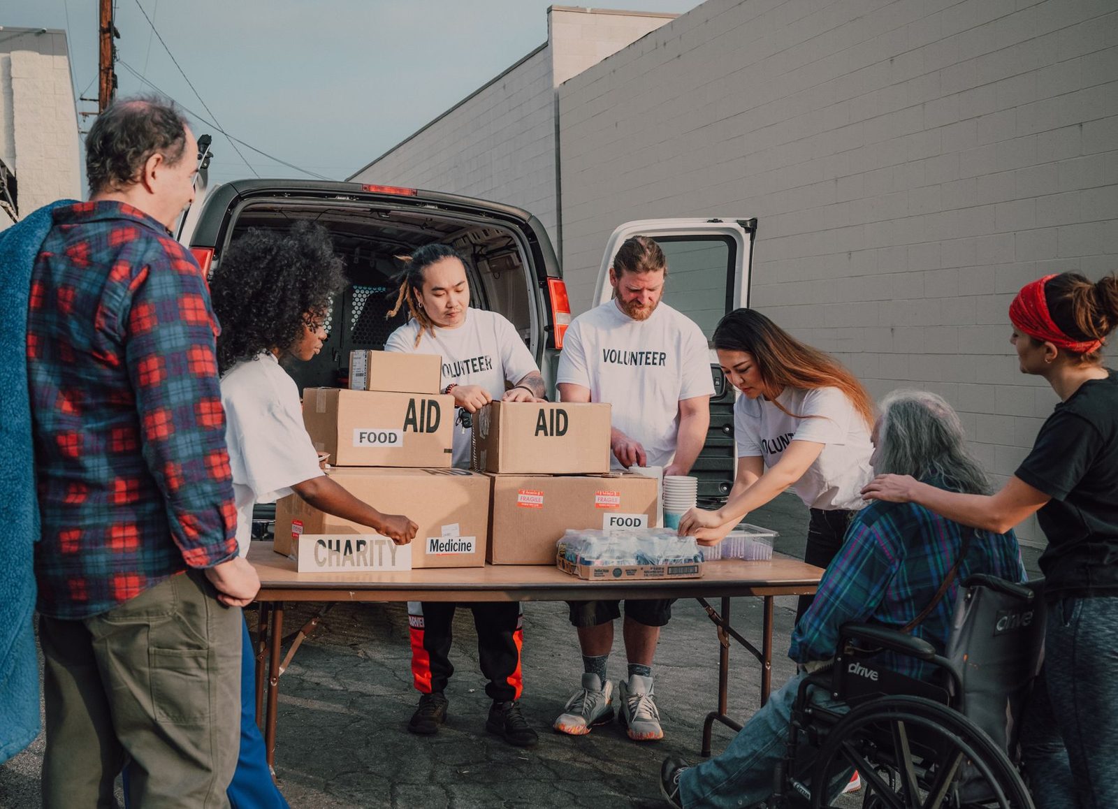 Volunteers handing out food and water boxes at a relief line