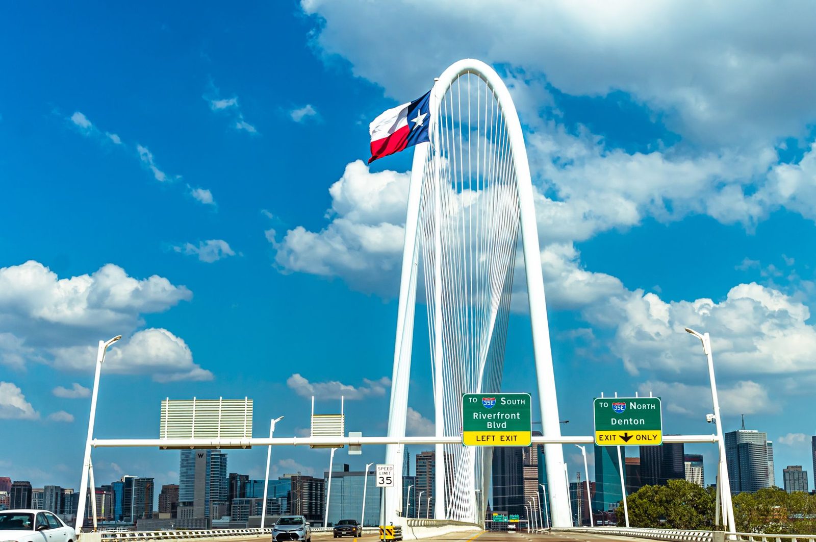 The Margaret Hunt Hill Bridge in Dallas under a Texas flag