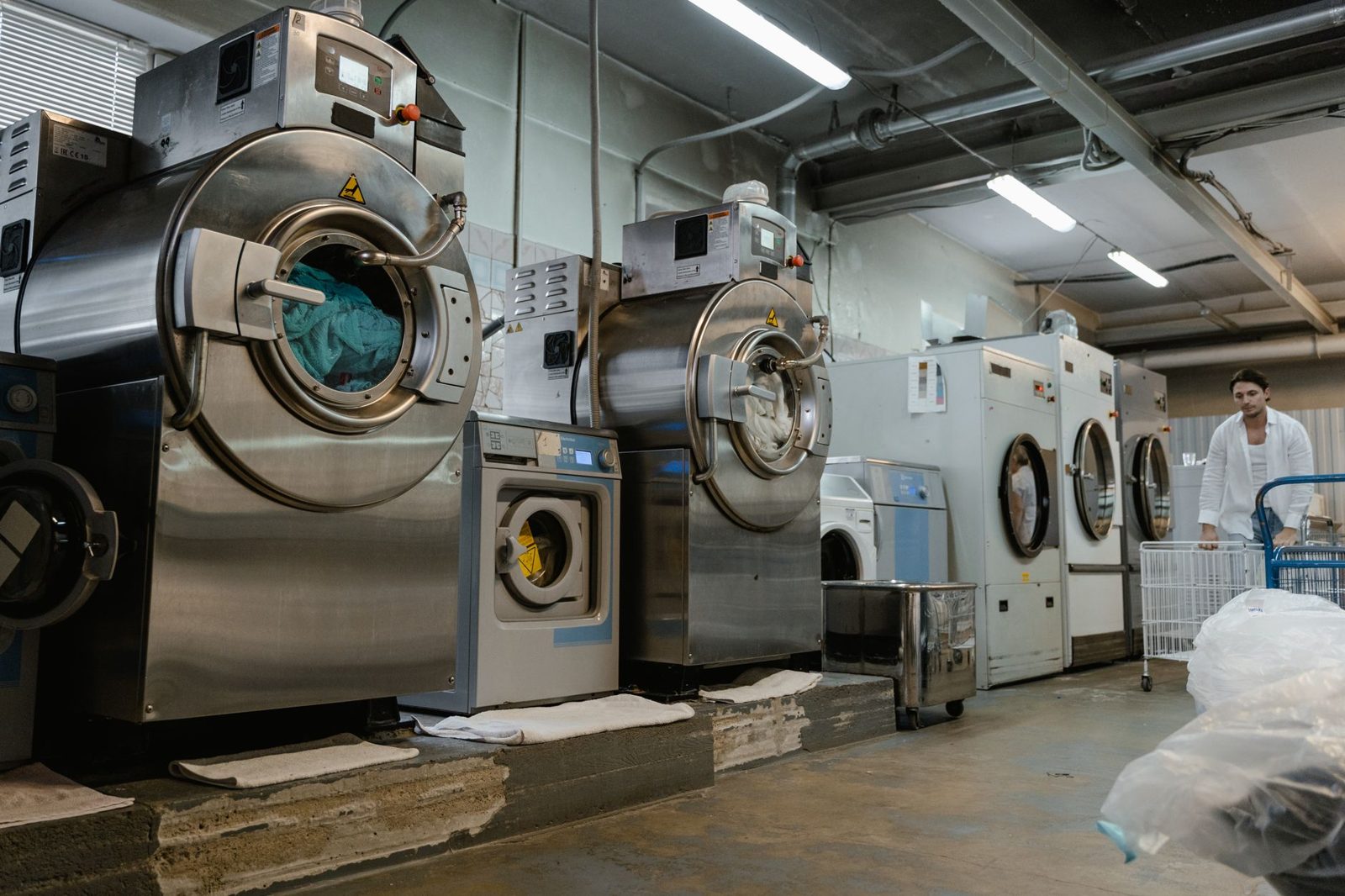 A row of industrial washers in a commercial laundry