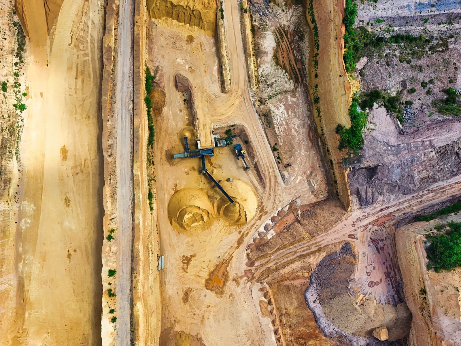 An open pit gold mine in the northern Nevada high desert with haul trucks on the benches