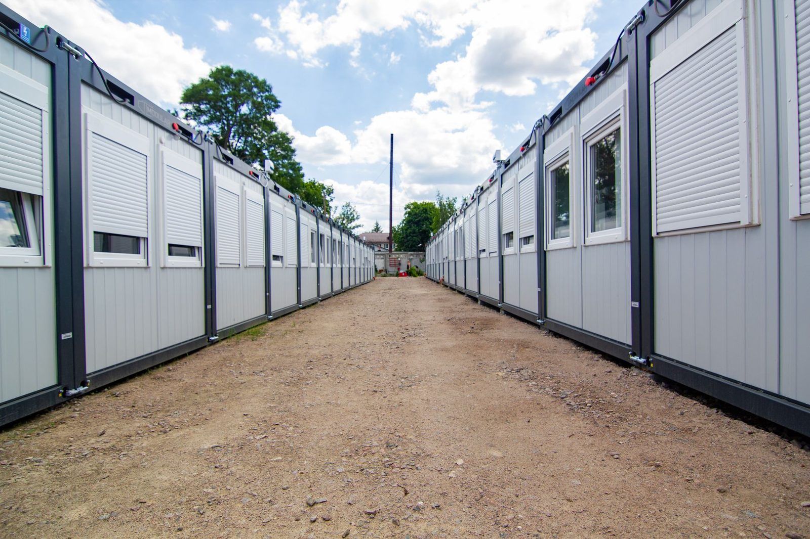 Rows of modular housing units along a dirt road at a crew camp