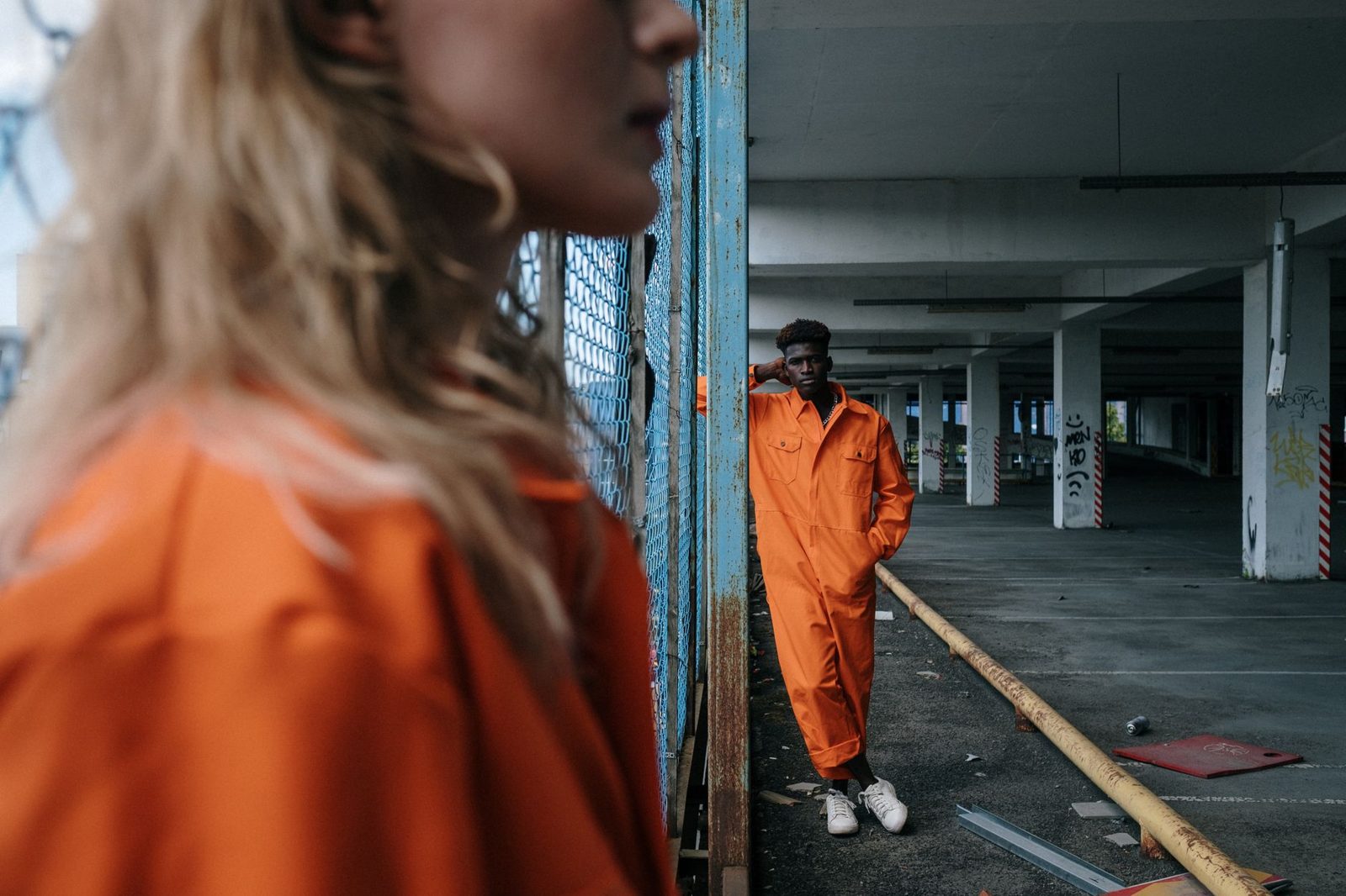 A worker in orange coveralls in a garage bay