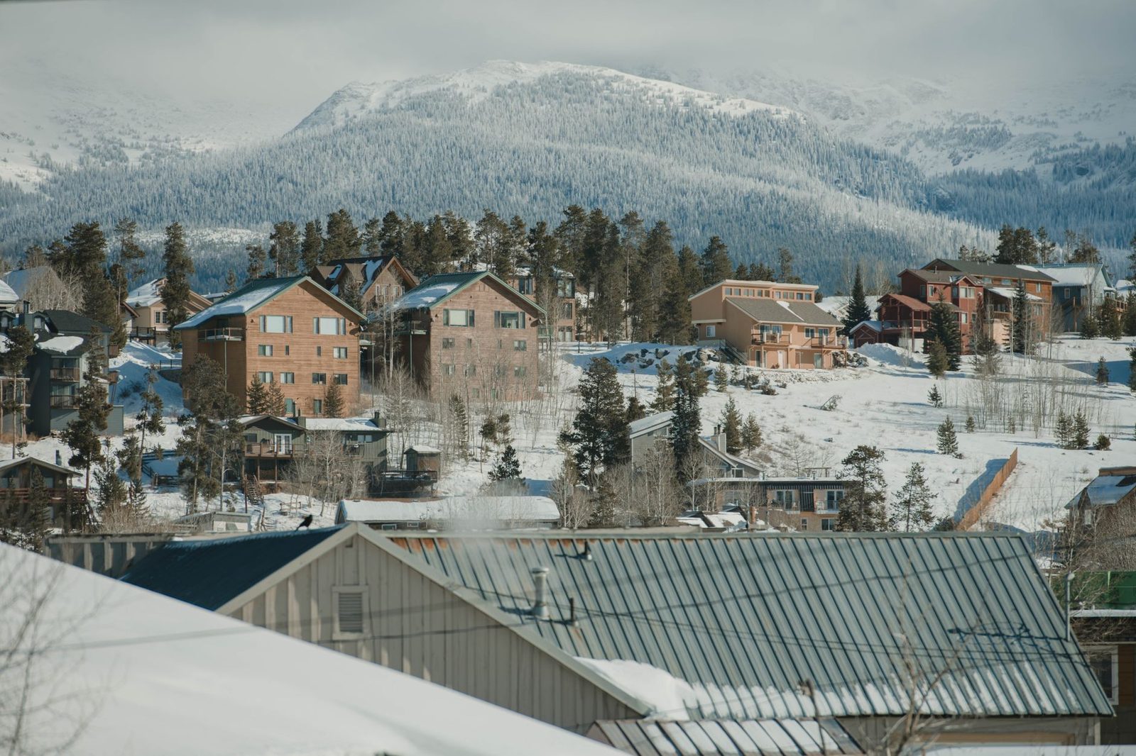 Snow-covered homes in Breckenridge with high peaks behind them