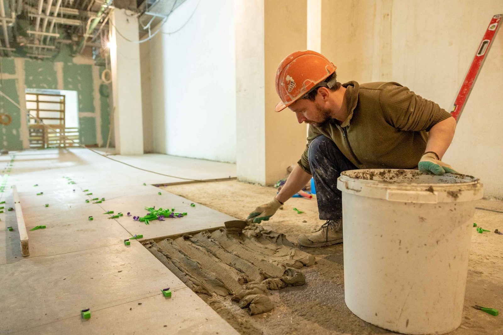 A tile worker setting a new floor during a building renovation