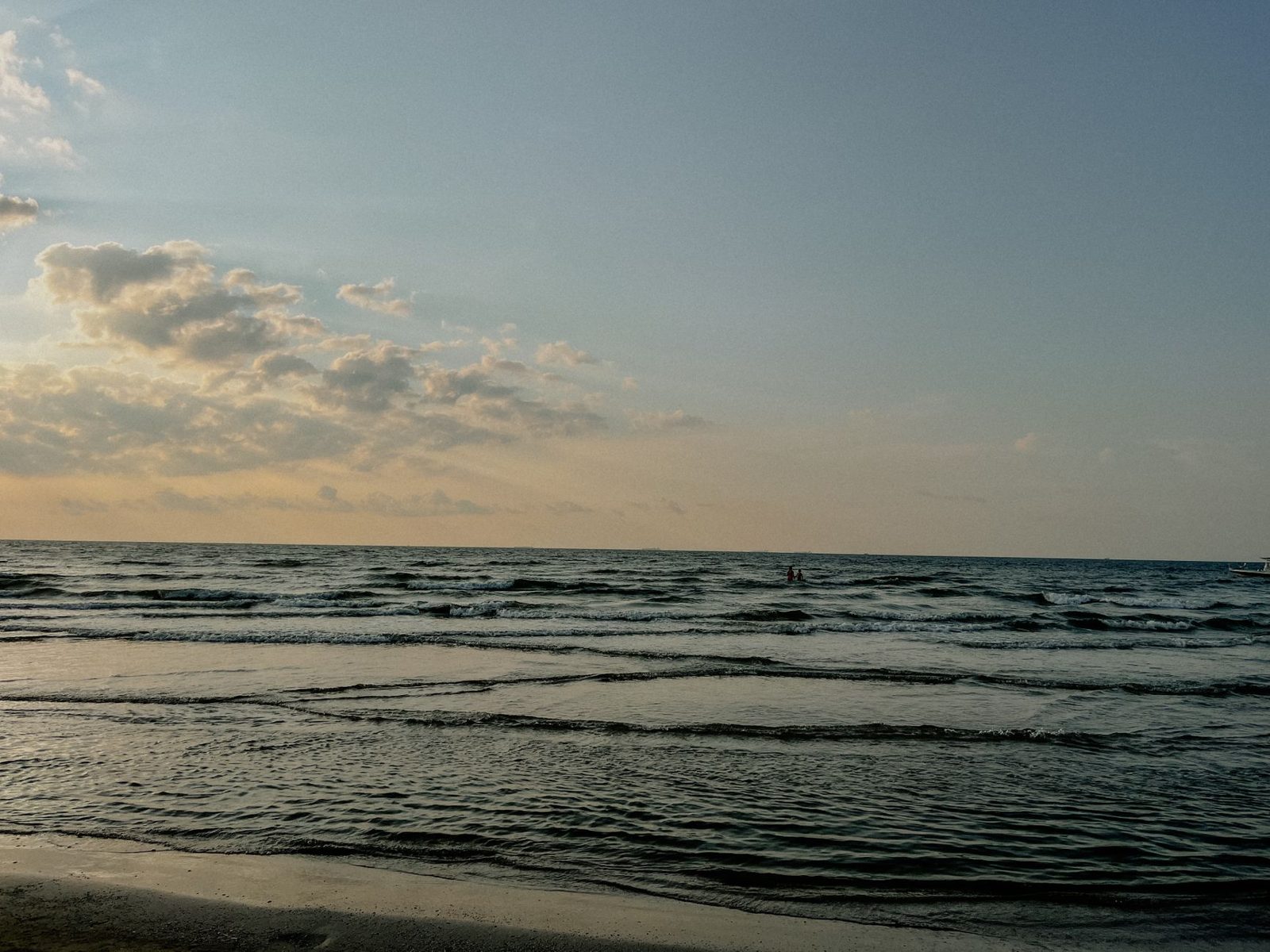 Gulf water rolling in under an evening sky