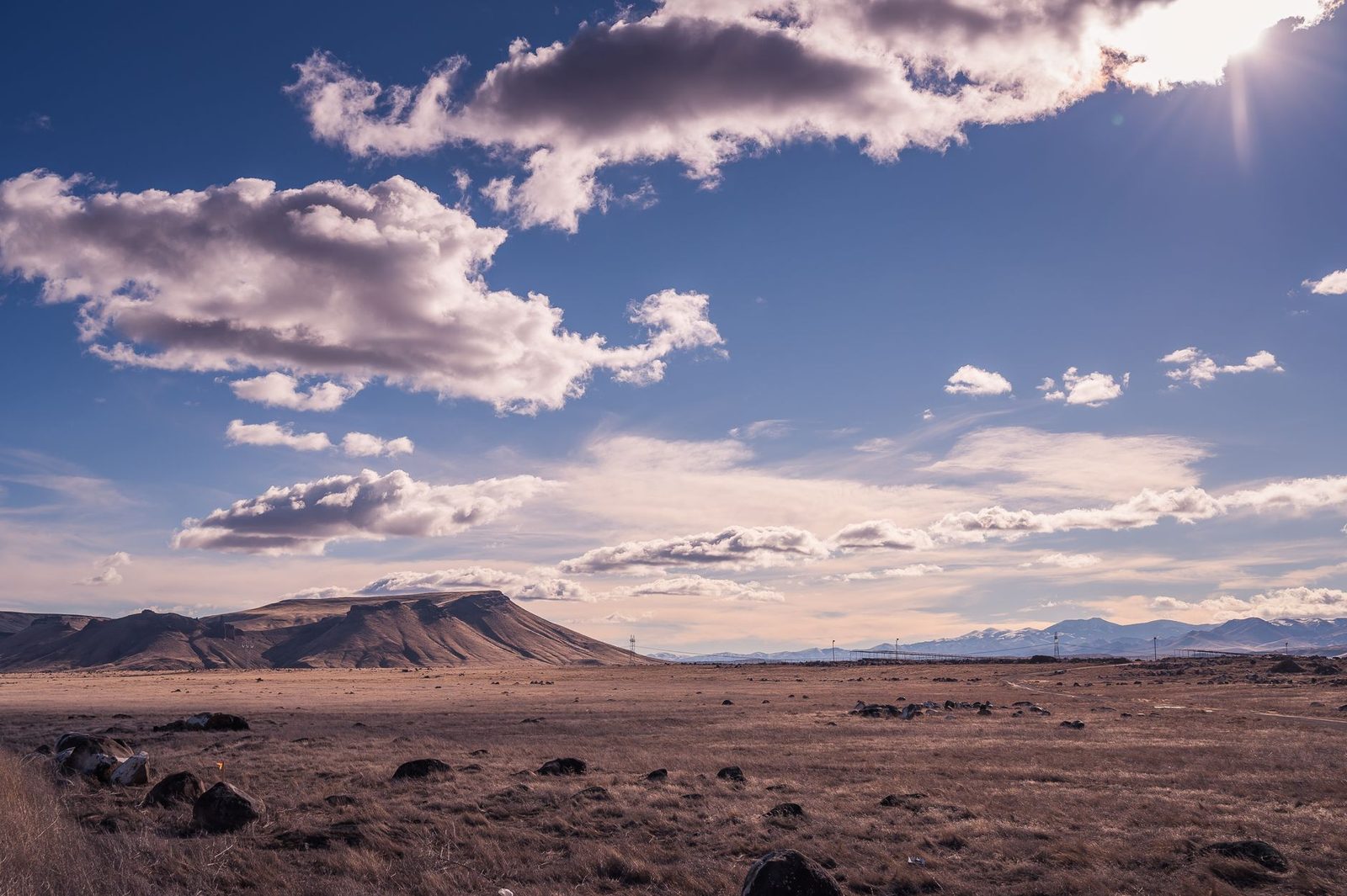 An open desert basin under a hot afternoon sky, the kind of ground outdoor crews work on all summer